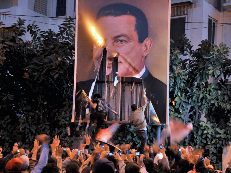 Image: Egyptian protesters tear down a poster of Egypt's President Hosni Mubarak